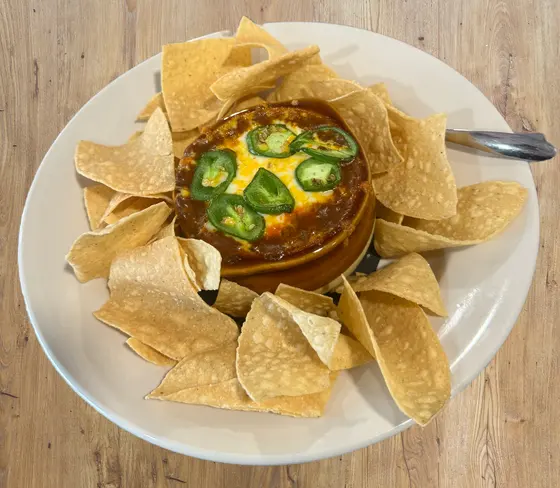 Chili topped with jalapenos over tortilla chips