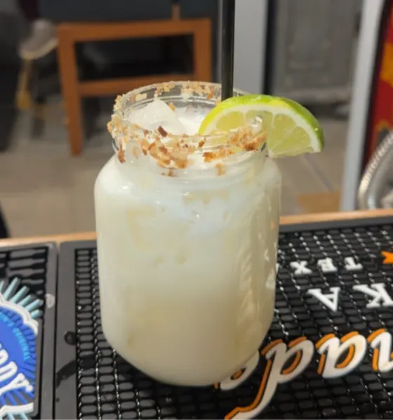 Toasted coconut margarita with a lime wedge