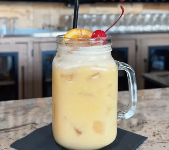 Frozen cocktail in a mason jar with a cherry