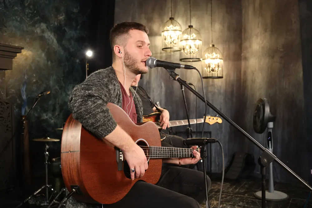 A singer with an acoustic guitar performing at the pub