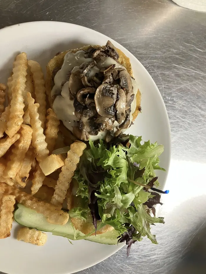 Mushroom Swiss smash burger with crinkle cut fries and a side salad