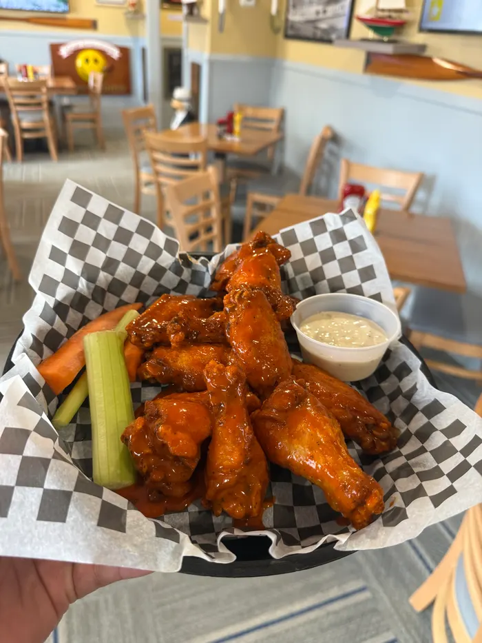 Wings in a checkered basket with celery, carrots and dip